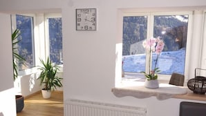 A room with a large window, a clock, a radiator, and a plant. - Apartment Gabi by Interhome (Wenns)
