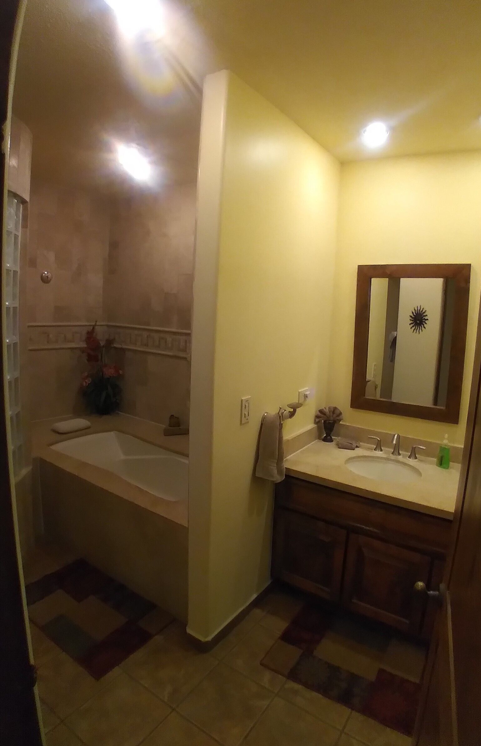 Un baño con bañera, lavabo y espejo.