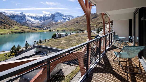 Un balcon avec vue sur un lac et des montagnes.