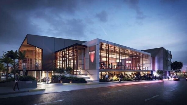 A modern building with large glass windows, a flat roof, and a well-lit entrance area. - Noble House~2 Bed/1Bath/1Car~Parklands + Transport (Wilston)