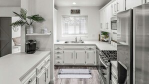 A modern kitchen with white cabinetry, a stainless steel refrigerator, and a built-in oven. - Beautiful house to relax and enjoy close to Camarillo outlets and beach (Camarillo)