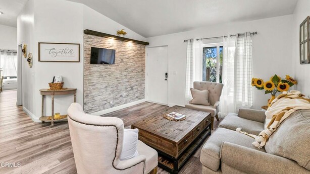A modern living room with a stone accent wall, a wooden coffee table, and a sofa. - Beautiful house to relax and enjoy close to Camarillo outlets and beach (Camarillo)