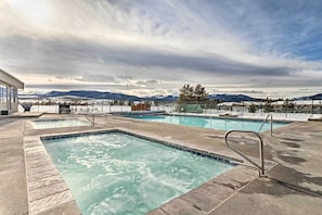 A pool area with multiple pools, a metal ladder, and a view of mountains in the background. - Eat, Sleep, Ski! Rustic Mtn Condo: WiFi,TV, HotTub (Fraser)