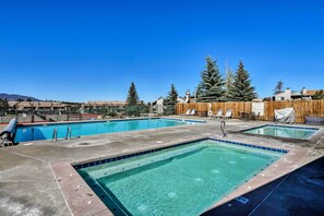 A rooftop pool with clear blue water, surrounded by lounge chairs and a wooden fence. - Eat, Sleep, Ski! Rustic Mtn Condo: WiFi,TV, HotTub (Fraser)
