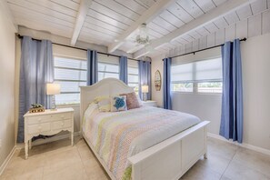 Cozy retreat with a comfortable bed, nightstand, and ceiling fan.