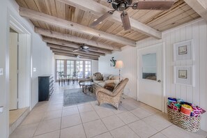 Relax in this inviting space with a comfortable sofa, dining table, and wicker chair.