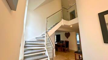 A multi-level interior with a staircase, a dining area, and a heart-shaped wall decoration.