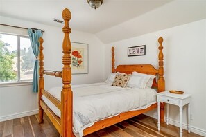 A four-poster bed with a wooden frame and white bedding, a small bedside table with a bowl, and a framed picture on the wall. - Classic Red Barn Loft w/Views in the Heart of Paso Wine Country & Pet Friendly! (Templeton)