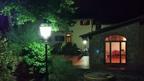 A courtyard with a stone building, a wooden barrel, and a lamp post.