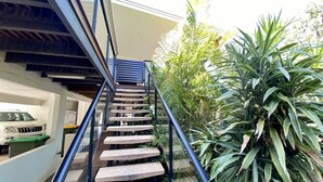 Una escalera moderna con barandilla de cristal que sube a un segundo piso.