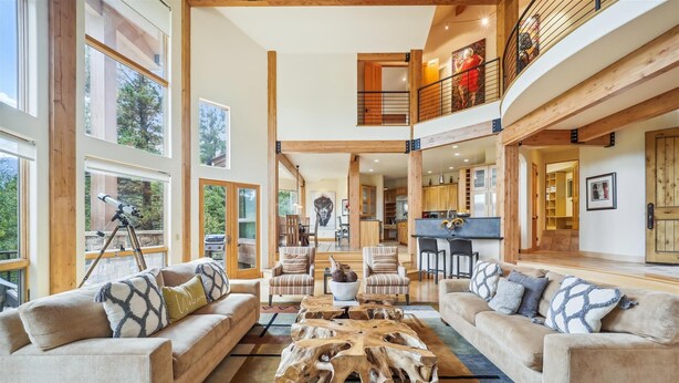 A spacious living area with high ceilings, large windows, and a mezzanine level.