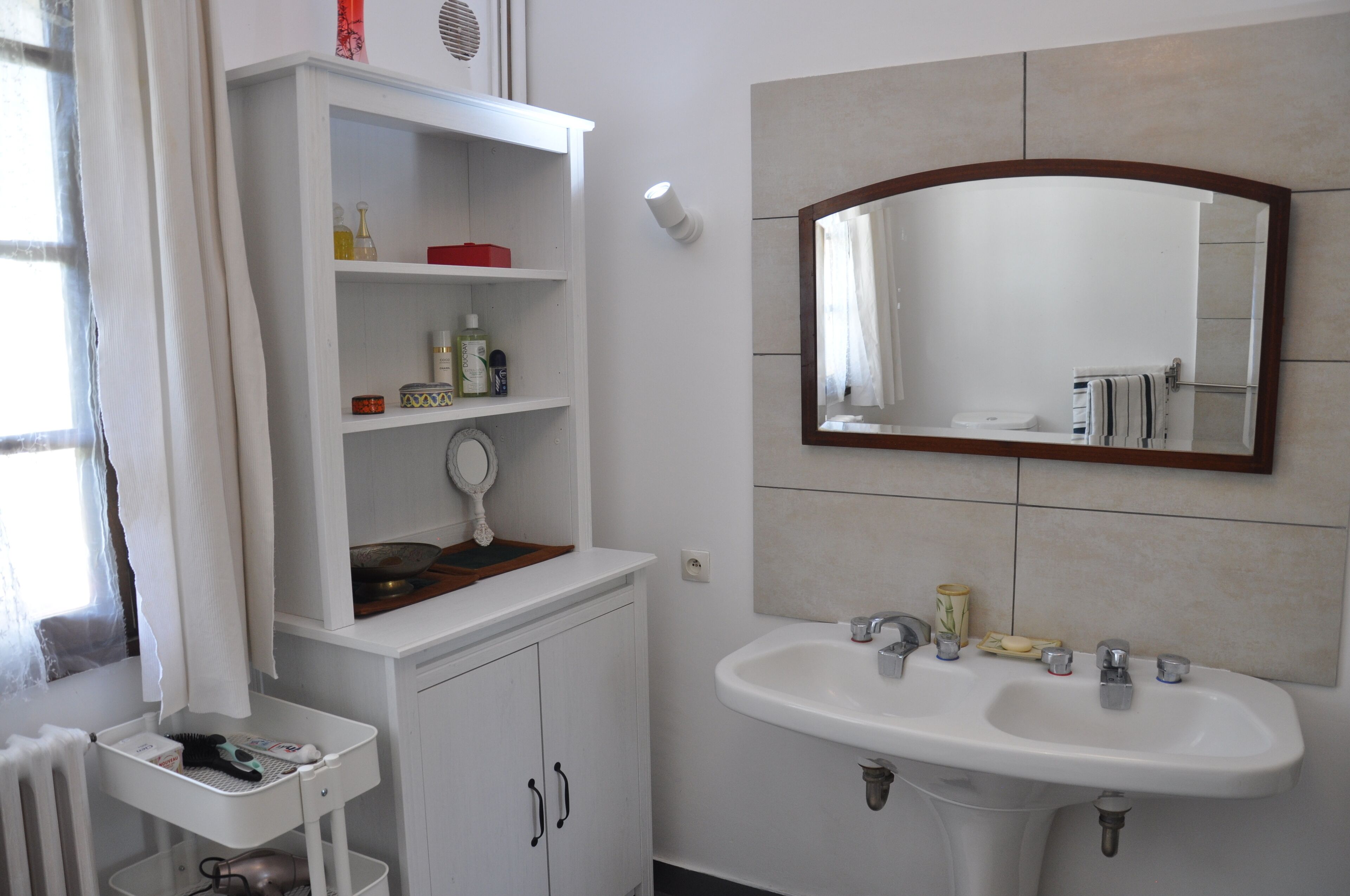 A bathroom with a white vanity, a sink, and a mirror.