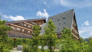 A modern building with a sloped roof and multiple balconies. - 800m des Remontées ! Appart Rustique + Sauna (Gresse en Vercors)