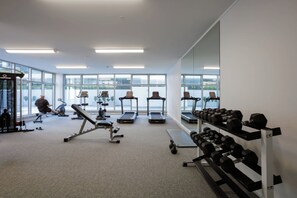 A gym with treadmills, dumbbells, and exercise equipment.