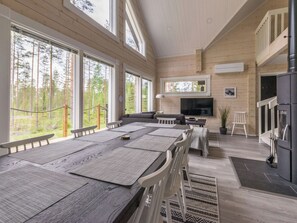 Une pièce spacieuse avec une grande table à manger en bois, un canapé et un téléviseur.