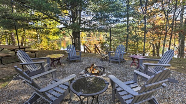 A campsite with Adirondack chairs, a fire pit, and a picnic table. - Eagle River Lakefront Oasis w/ Private Dock! (Eagle River)