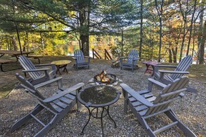 A campsite with Adirondack chairs, a fire pit, and a picnic table. - Eagle River Lakefront Oasis w/ Private Dock! (Eagle River)