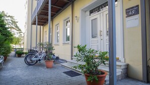Un bâtiment à la façade jaune, avec une porte blanche portant l’inscription « ATLANT » et une enseigne indiquant « Strandpromenade 45 ».