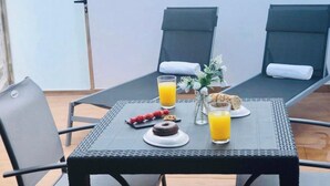 A table with breakfast items including croissants, a chocolate cake, and a fruit skewer, along with two glasses of orange juice. - Canaryislandshost l Nazaret Suites (Nazaret)