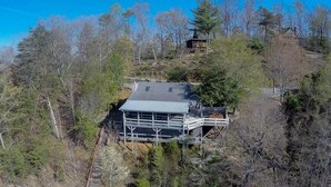 A house with a metal roof, surrounded by trees and a small deck. - A Beary Nice View- Pet Friendly | Screened Porch | My Mountain | No steps to enter (Morganton)