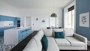 A modern living room with a sofa and a dining area. - A lews castle that sleeps 2 guests  in 1 bedroom (Isle of Lewis)