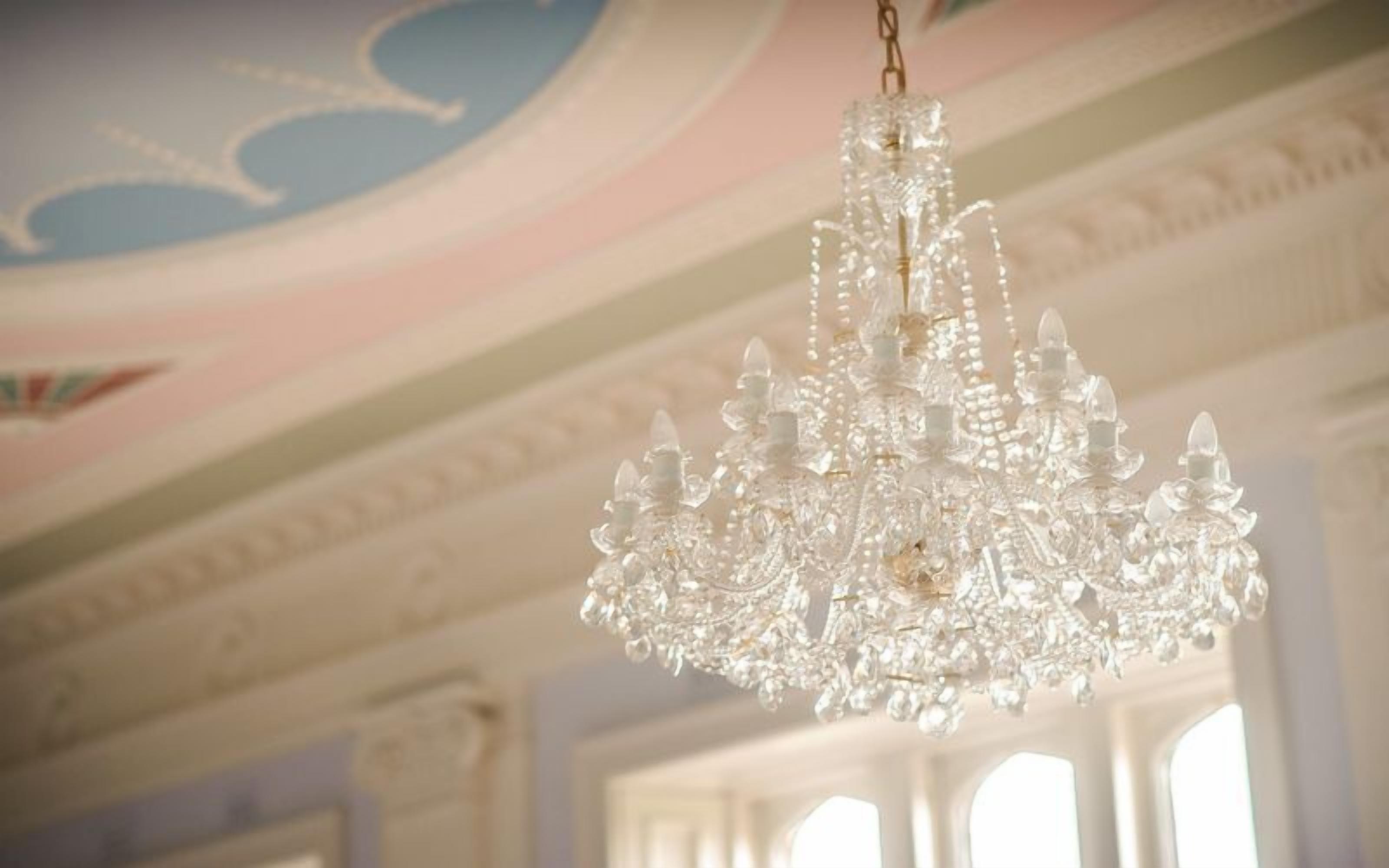Ein Kronleuchter mit mehreren Kristallstufen, der von der Decke hängt.