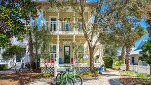 A two-story building with a balcony, a bicycle parked in front, and a pathway leading to the entrance. - ☀️Bikes-Pools-30A-Close to Beach-Chihuahua Flats (Santa Rosa Beach)