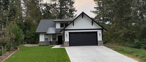 A two-story house with a garage, a front lawn, and a driveway.