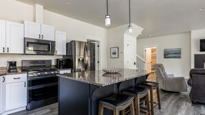 A modern kitchen with a large island, stainless steel appliances, and a bar stool seating area. - Brand new incredible Columbia Falls home - Flathead river walking trail - A/C for hot summer days (Columbia Falls)