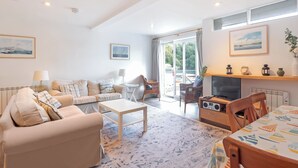 A spacious living room with a sofa, coffee table, and a TV area. - 2 bedroom accommodation in Fowey (Fowey)