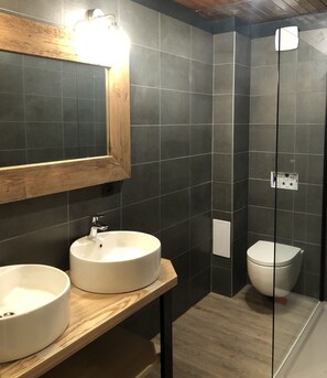 A modern bathroom with two sinks, a toilet, and a glass shower enclosure. - APART 2 ALPS, 8 PERS, STATION CENTER, BEAUTIFUL VIEW (LES DEUX ALPES)