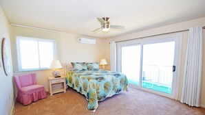 A bedroom with a bed, a chair, a nightstand, a ceiling fan, and a sliding glass door to the outside. - Ocean Club 4011-Oceanfront 40th St, Free WiFi, W/D, AC (Ocean City)