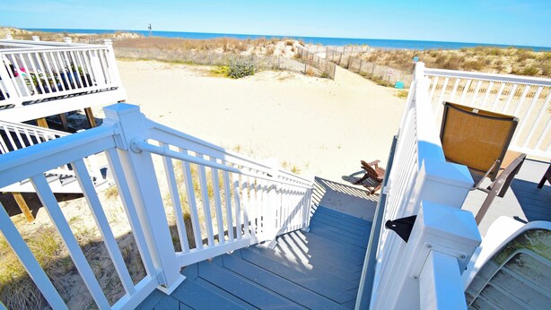 A wooden deck with white railings overlooking a sandy beach and dunes. - Ocean Club 4011-Oceanfront 40th St, Free WiFi, W/D, AC (Ocean City)