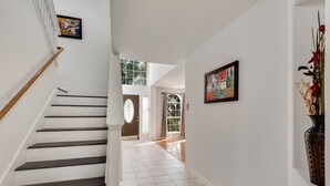 A staircase with wooden steps leading to a door with a glass panel. - North East Luxury Retreat (Round Rock)