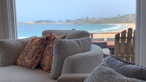 Ein Wohnzimmer mit Blick auf Strand und Meer.
