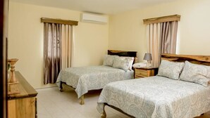 Une chambre avec deux lits, une table de chevet avec une lampe et une commode.