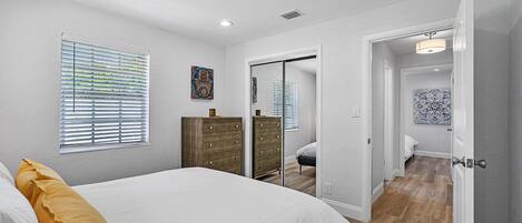 Un dormitorio con cama, cómoda y vestidor.