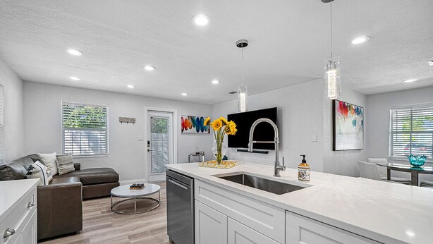 A modern kitchen with a large island, built-in appliances, and a dining area with a round table.