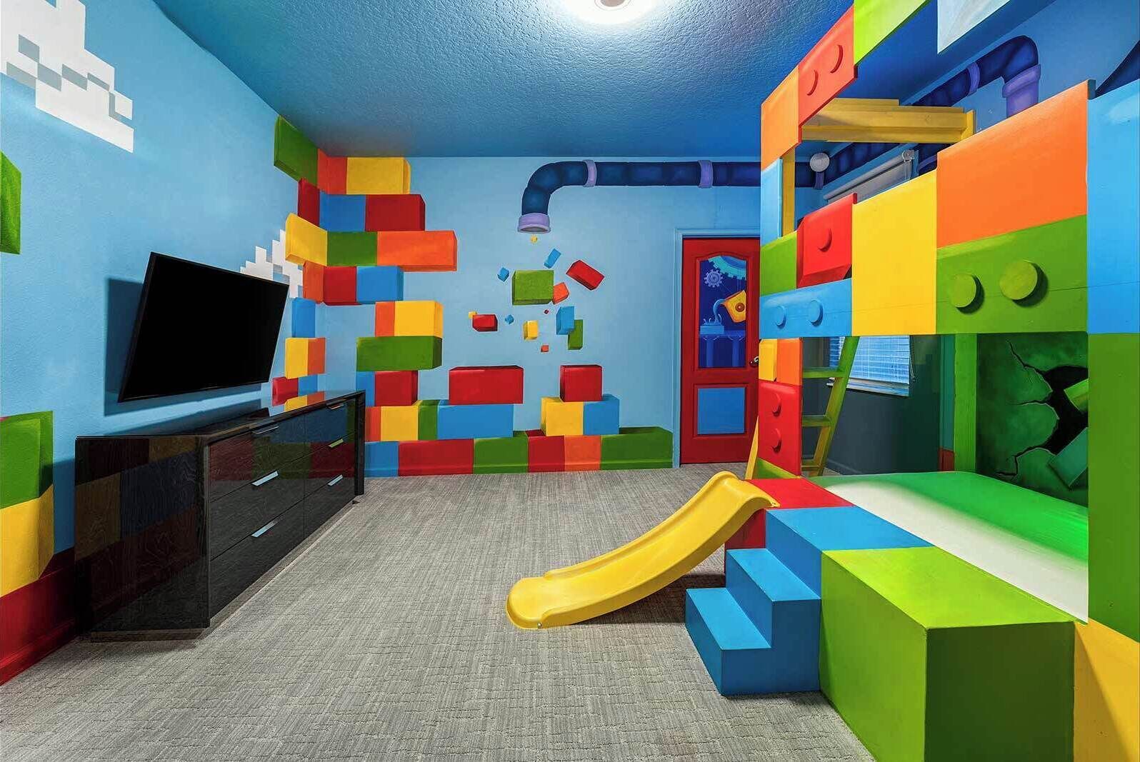 A playroom with colorful blocks, a TV, and a slide.