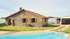 Una casa in pietra con piscina, una zona relax esterna coperta e un'auto nelle vicinanze.