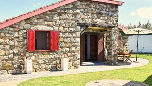 Un edificio in pietra con tetto rosso e porta in legno.