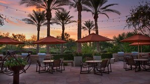 An outdoor patio with tables and chairs, string lights, and palm trees. - Marriott Canyon Villas - Two Bedrooms-Direct from Owner  (Phoenix)