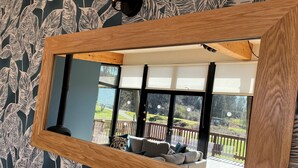 A room with a large mirror reflecting a balcony with outdoor seating and a view of a garden. - A yorkshire dale that sleeps 6 guests  in 3 bedrooms (Richmond)