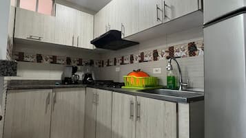 Refrigerador, cafetera y tetera, utensilios de cocina y comedor