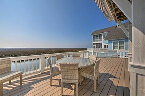 A wooden deck with wicker furniture and a view of the ocean. - Manteo Waterfront Resort Home w/ 30-Ft Dock! (Manteo)