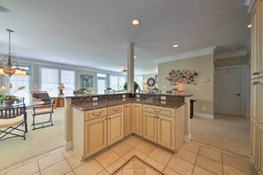 A spacious kitchen with a large island, beige cabinetry, and a decorative backsplash. - Manteo Waterfront Resort Home w/ 30-Ft Dock! (Manteo)
