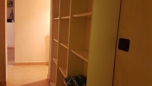 Ein Korridor mit einem weißen Regal und einer Tür.