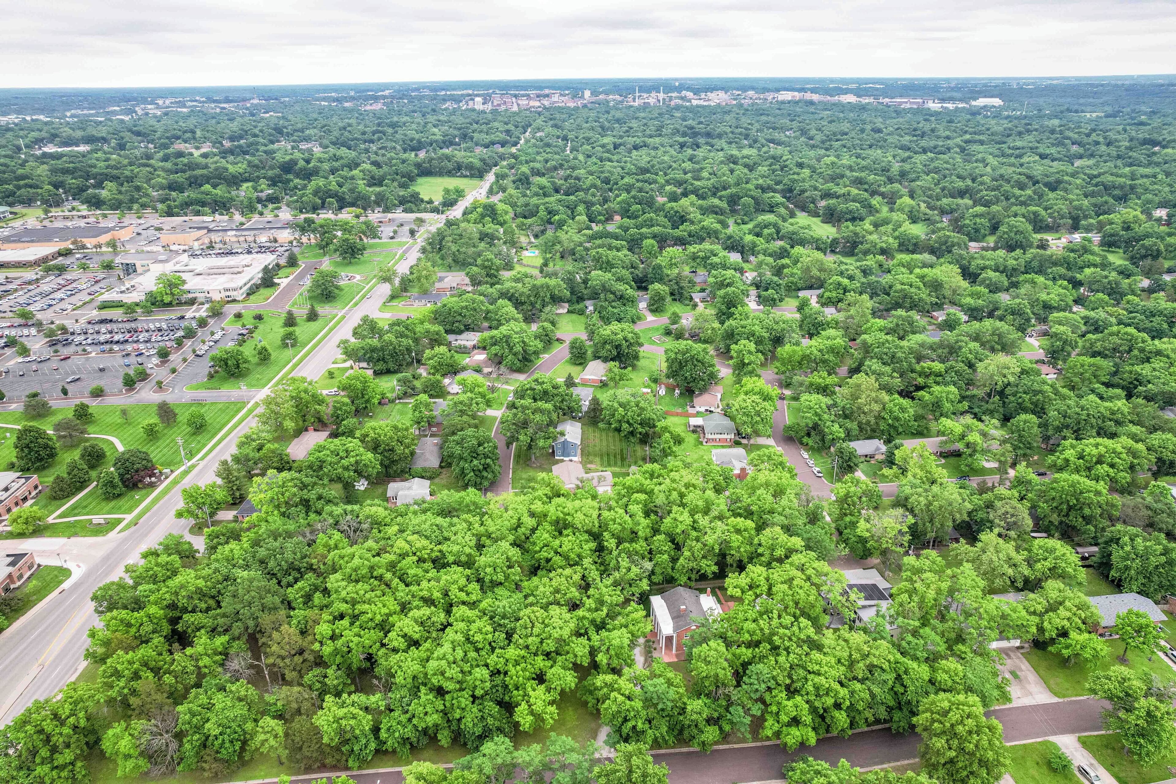 Vue aérienne d’un quartier résidentiel avec des maisons, des rues et un parking.
