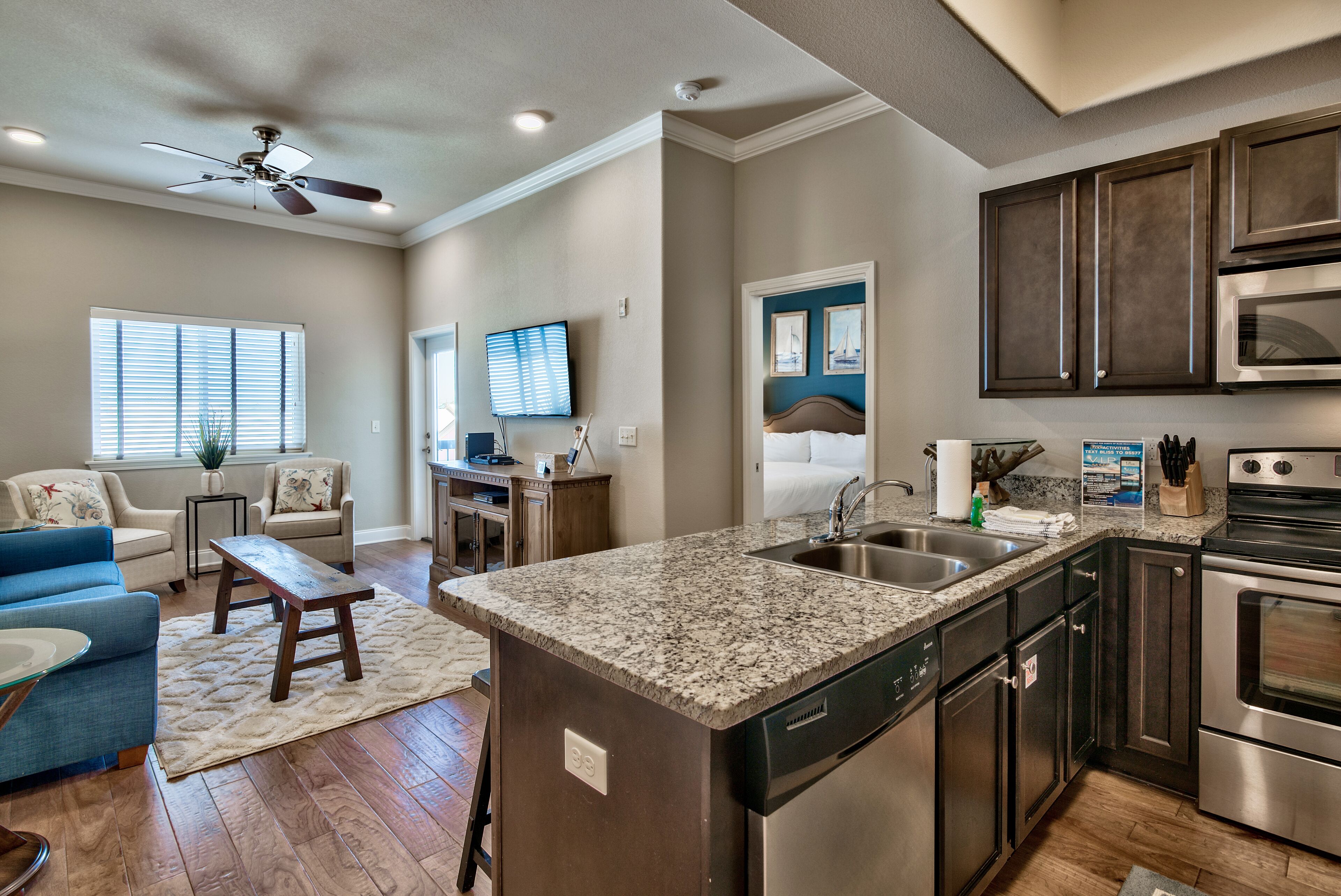 A modern kitchen with granite countertops, stainless steel appliances, and dark cabinetry.