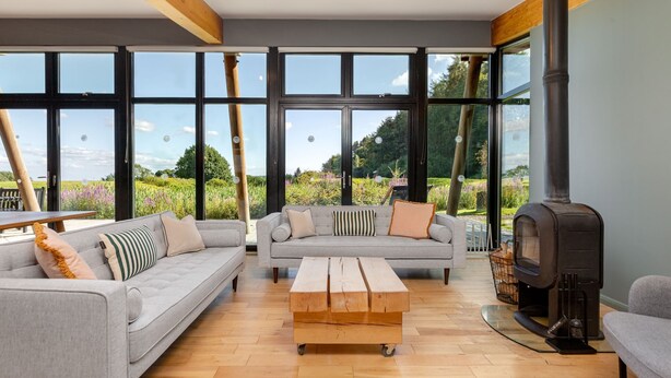 A modern living room with a sofa set, a wooden coffee table, and a fireplace.